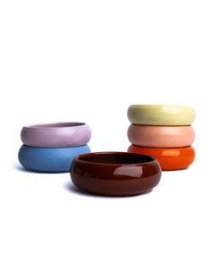 three different colored bowls sitting next to each other