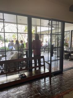 a woman standing in front of a glass door