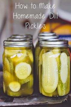 two jars filled with pickles sitting on top of a table