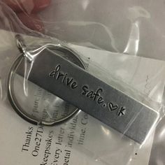 a metal keychain with the word drive safe on it