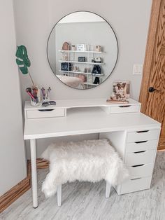 a white desk with a mirror and some drawers