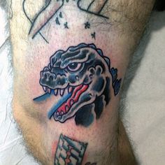 a man's leg with a tattoo on it that has an alligator head and razor blade