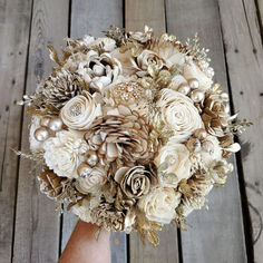 a bridal bouquet made up of flowers and pine cones