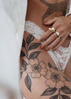 a close up of a person's stomach with flowers tattooed on the bottom and side