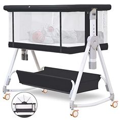 a black and white baby crib with wheels on the bottom, next to it's changing table