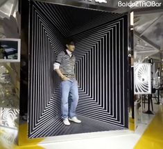 a man is standing in front of a black and white striped room with yellow flooring