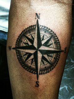 a black and white compass tattoo on the leg