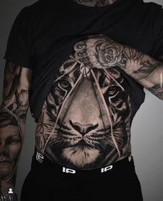 a man with tattoos on his chest and tiger tattoo on his back, wearing a black t - shirt