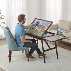 a man sitting at a table with a board game in front of him and holding a pen