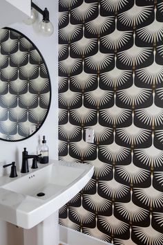 a white sink sitting under a bathroom mirror next to a wall mounted faucet