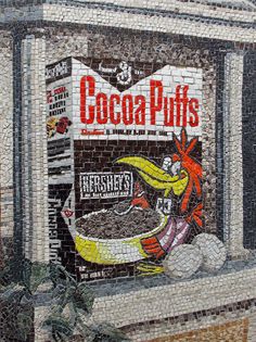 a mosaic depicting a banana advertisement on the side of a building with words cocoa puffs