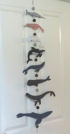 a group of fish hanging from the side of a white door with black and red handles