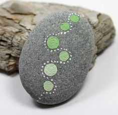 a rock with green dots painted on it