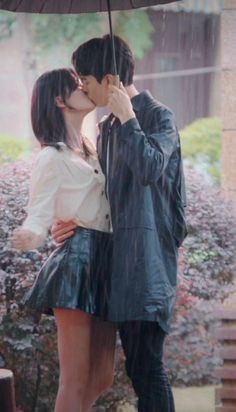 a couple kissing under an umbrella in the rain