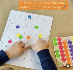 a child is making christmas lights on a sheet of paper with the words, 2 place dot stick christmas lights on numbered strings