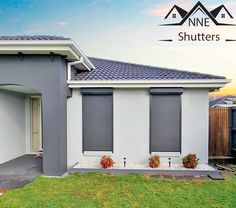 a house with shutters on the front and side of it in an area that has grass