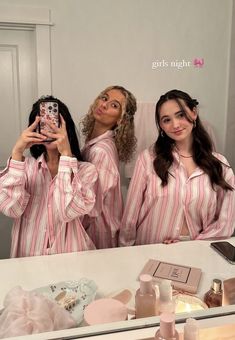 two women in pink striped pajamas taking a selfie