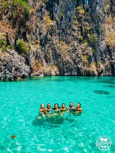 four people are floating in the clear blue water