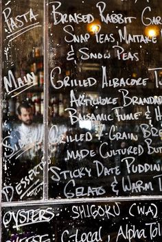 a menu written on the window of a restaurant