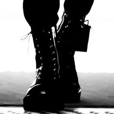 black and white photograph of woman's legs in high heel boots with laces