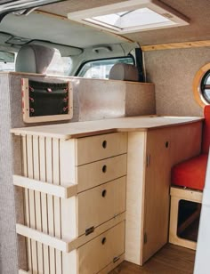 the inside of a camper with drawers, cabinets and a table in front of it