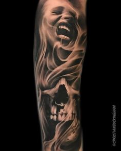 a man's arm with a black and white tattoo on it, depicting a screaming skull