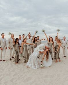 a group of people standing on top of a beach next to each other holding flowers