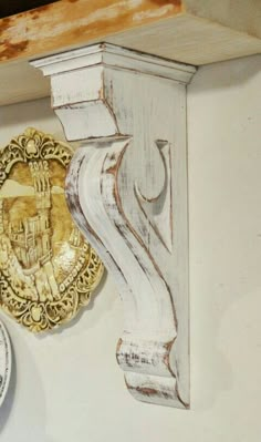 two clocks are on the wall next to an ornate shelf with a coat of arms