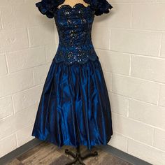 An Absolute Stunner! This Jessica Mcclintock Dress Was Made In The 1980’s In The Usa! Intricate Bodice With Sequins That Change Color As You Move! Flares Out In A Metallic Blue Gown With Tulle Underneath To Add Volume! Sleeve Can Be Worn On Or Off Shoulders And Are Adorned With Flowers And Sequins. This Is A Work Of Art, Beautiful, Craftmanship. *Please Note Size Says 8 But Would Not Zip Up My Mannequin All The Way Which Is An 8. Please Reach Out With Any Questions! Measurements: Bust 14 Inches Blue Knee-length Vintage Dress For Party, Blue Midi Vintage Dress For Party, Vintage Short Sleeve Prom Dress, Fitted Vintage Blue Party Dress, Fitted Vintage Blue Dress For Party, Blue Fitted Vintage Dress, Fitted Blue Vintage Dress For Wedding, Blue Vintage Dress With Fitted Bodice, Fitted Blue Vintage Dress For Costume Party