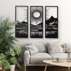 three black and white paintings hang on the wall above a couch in a living room