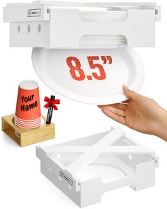 a person holding up a white tray with the number 85 on it and another item next to it