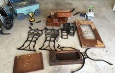 several pieces of metal sitting on top of a cement floor next to wooden boxes and other items