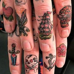 two fingers with different tattoos on them and one has a skull, an anchor, a pirate ship