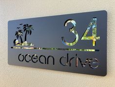 a metal sign that says ocean drive with palm trees