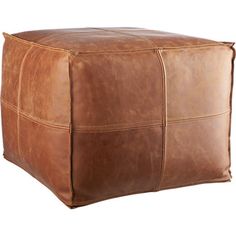 a brown leather square ottoman sitting on top of a white floor