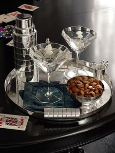 a tray with martini glasses and nuts on it