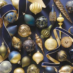 an assortment of christmas ornaments with ribbons and decorations on the top one is gold, blue, and silver