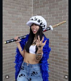 a woman in a costume holding a baseball bat and making the peace sign with her hand