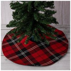 a small christmas tree in a red and black plaid pot holder