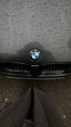 the front end of a bmw car with rain drops on it