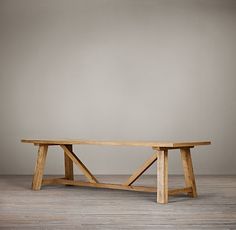 a wooden table sitting on top of a hard wood floor next to a gray wall