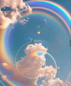 two rainbow rings are in the sky above clouds