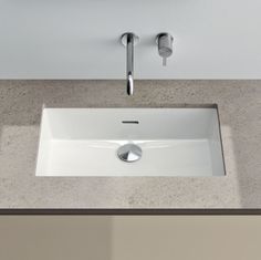 a white sink sitting on top of a counter next to a faucet and soap dispenser