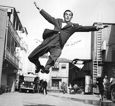 a black and white photo of a man jumping in the air