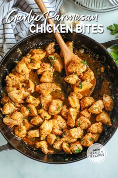 a pan filled with chicken bites and garnished with parsley on the side