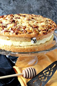 a cake sitting on top of a glass plate next to a spatula and honey comb