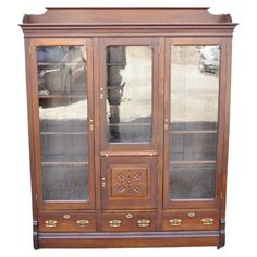 Antique Eastlake Victorian Walnut Wavy Glass Triple Bookcase Display Cabinet. Item features 16 adjustable wooden shelves (need wooden shelf slats to insert four), 3 dovetailed drawers, original wavy glass, solid brass hardware, carved backsplash, nice narrow form, nicely carved detail, pullout surface, rolling casters, large impressive size, very nice antique item, unlocked, no key. Circa 19th Century. Measurements: 80.5" H x 66" W x 13.5" D. Eastlake Victorian, Bookcase Display, Wooden Shelf, Wooden Shelves, Display Cabinet, Antique Victorian, Antique Items, Brass Hardware, Storage Cabinets