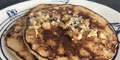 two pancakes on a blue and white plate topped with nuts