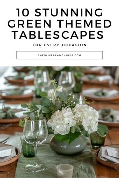 the table is set with white flowers and greenery