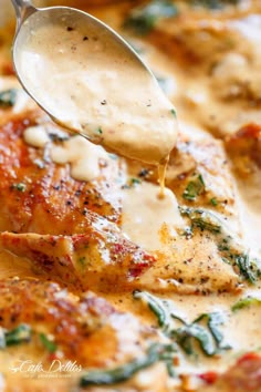 a close up of a spoon with food on it and sauce being drizzled over the chicken